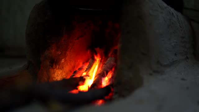 Rural Vintage Kitchen using firewood in-earthen chulhas for cooking food. Indian countryside footage
