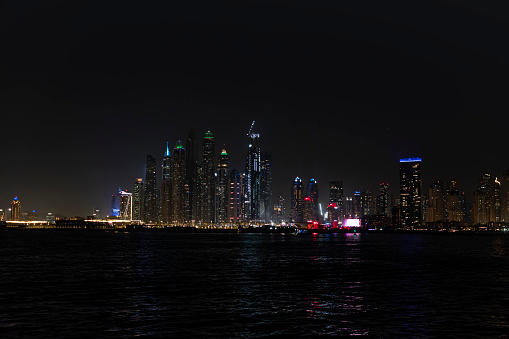 City at night, panoramic scene of downtown reflected in water, Dubai.
