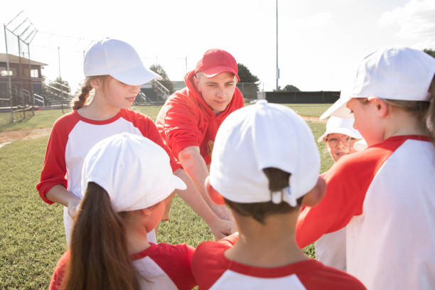istock Young athletes at the elementary school level collaborate in a co-ed little league baseball team, supported by dedicated coaches on a lively ballfield 2128665960