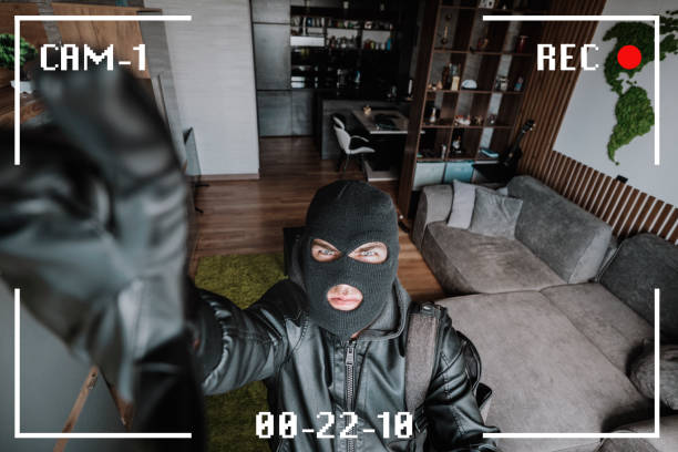 istock Being Caught. Robber entering house, holding crowbar and looking at CCTV camera, high angle view from above. robber noticed a security camera. 2128666495