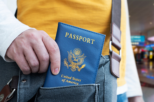 hand holding passport with bokeh background, jorney and travel concept. Passport check at the border. A man will find a passport for obtaining a visa at the airport.