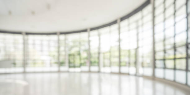 istock Office building lobby hall blur background or blurry school hallway corridor interior view looking toward empty corridor entrance, glass curtain wall and floor with exterior light illumination 2128672359