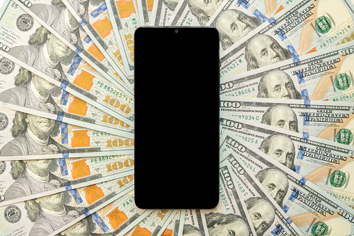 smartphone screen on US dollar banknotes background for design purpose. a blank screen on a smartphone with money.