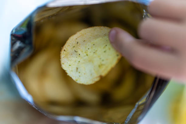 istock A child's hand takes chips from a pack. Hand picking potato chips inside snack bag 2128673997