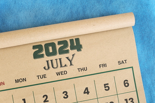 July 2024 calendar flat lay in blue background with copy space.
