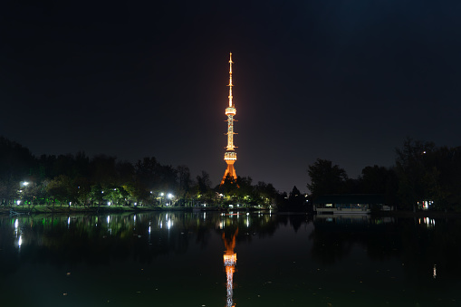 Tashkent TV Tower seen at night from small river