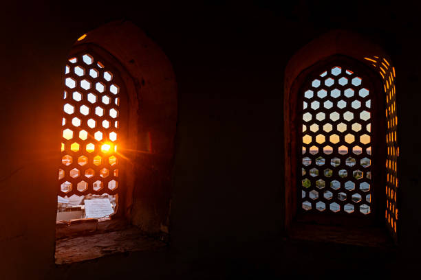 eastern religion, mosque, mystical rays of light from under the dome windows. sunset view above the city through the lattice on the window of the minaret.