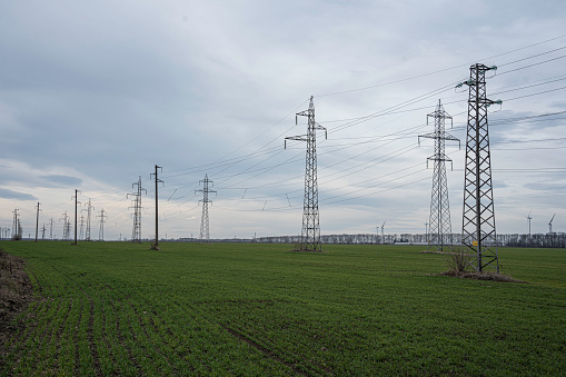 High voltage towers transport electric energy. Transmission of alternative and renewable energy.