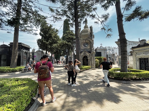 buenos aires, argentina - 28 October 2022: people visiting and walking around the world famous landmark the La Recoleta cemetery with historic monumental graves with sculptures an architectural wonder