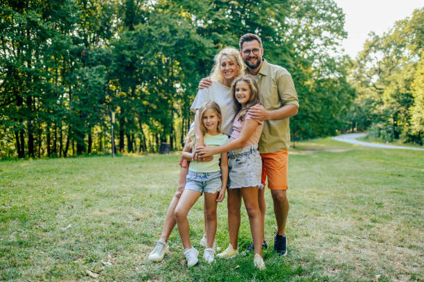 istock A happy family is standing in nature and hugging while smiling at the camera. 2128683799