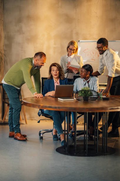 istock Interracial staff gathered around laptop at office and typing report. 2128684313
