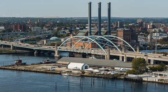 Industrial area with Providence River Bridge with traffic on it. Ferry Pier on Fox Point at the front.