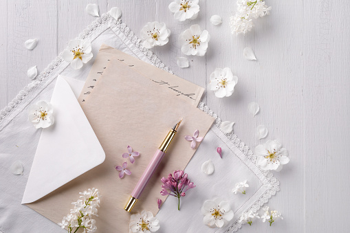 Envelope with paper, fountain pen and white flowers