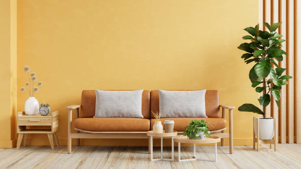 istock Living room wall mockup with leather sofa and decor on yellow wall background 2128765431