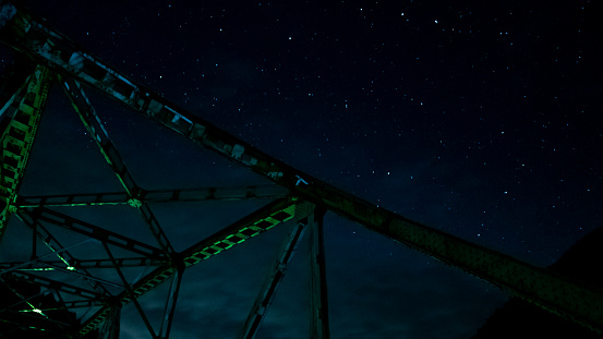 The steel bridge over the starlit sky creates a fantastic sight along with the serenity of the night!