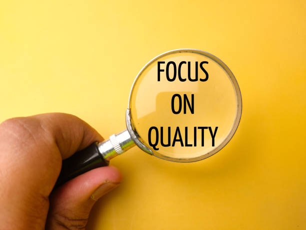 istock Hand holding magnifying glass with the word FOCUS ON QUALITY 2128775657