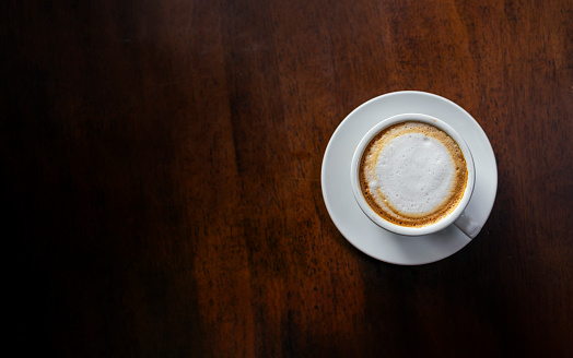 hot coffee and bean on black wooden table background. top view