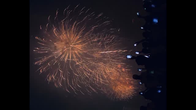 spectators film firework show on new year celebrations in Bangkok, Thailand