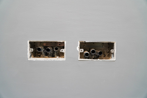 Hole in concrete wall, Unfinished electrical mains outlet socket without electrical wires - concrete wall.