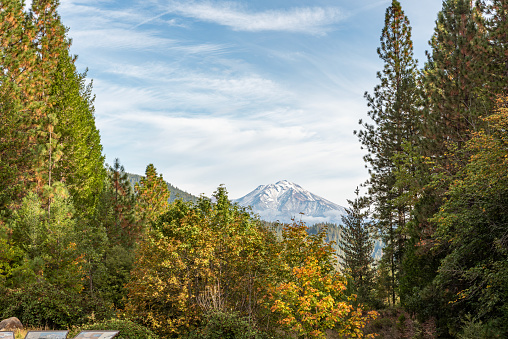 Mount Shasta viewed from Interstate five rest stop in the Autumn with partly cloudy blue sky and copy space