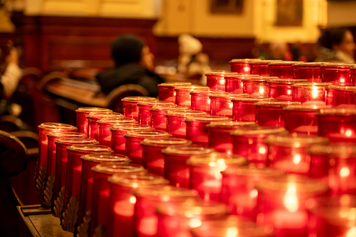 Rows of lit candles in a church