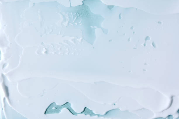 istock Abstract cosmetic background made of white cream on a blue background. 2129079581
