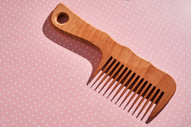 istock Wooden comb on a pink polka dot background. 2129088288