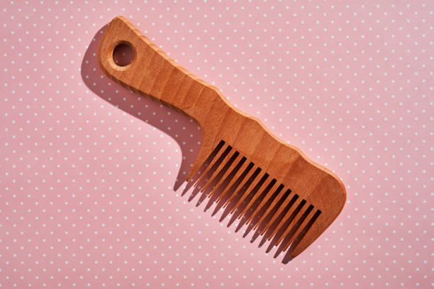 istock Wooden comb on a pink polka dot background. 2129089172