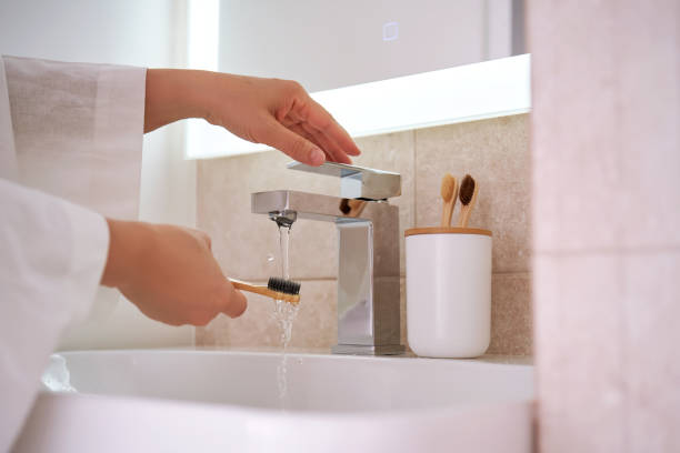 istock Women's hands under running water in the bathroom. Morning routine. 2129092782