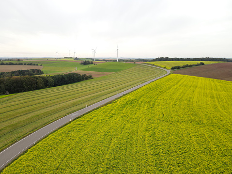 View from above of agriculture land with a long asphalt road in autumn