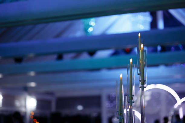 An elegant chandelier illuminates a banquet hall with a ceiling draped in transparent fabric. Concept: luxury event spaces, interior design. Copy space.