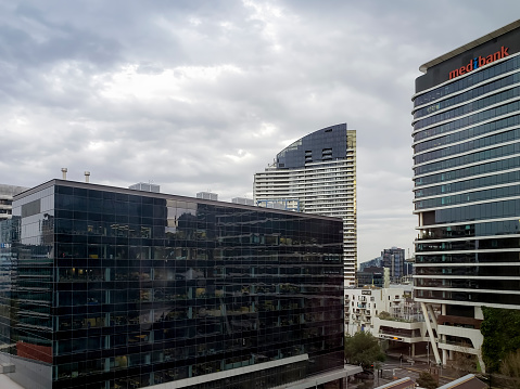 Melbourne, Australia - Aug 29, 2022: The Medibank Building in modern high-rise office architectural design. Other corporate or office building towers around. Overcast afternoon sky.