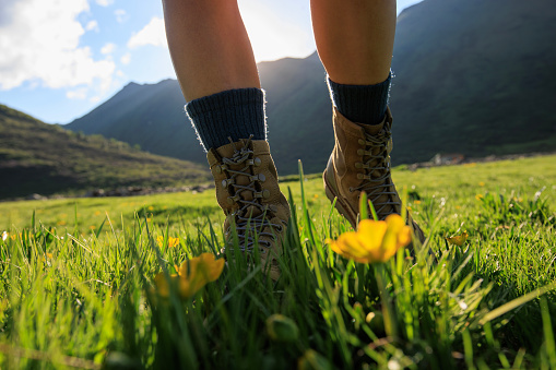 Woman hiker walking on trail in grassland