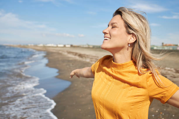 istock Happy woman enjoying day on a beach 2129251501