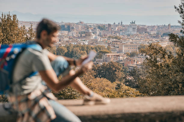 istock Young male tourist reading a map while exploring big city 2129253565