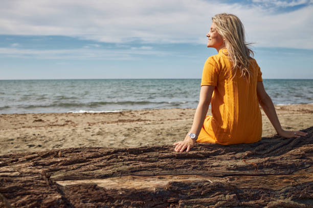 istock Happy woman enjoying day on a beach 2129254096
