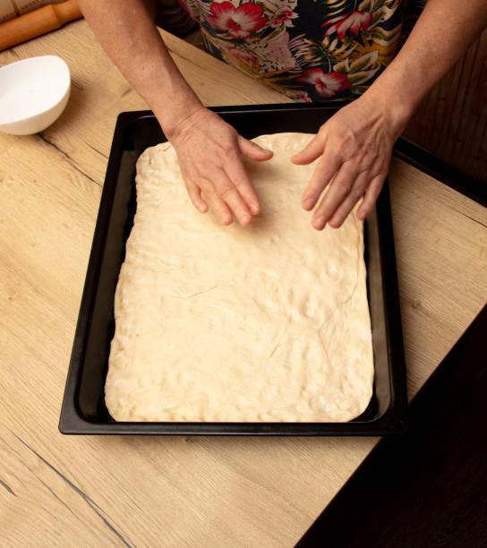 istock A woman makes a pie from dough on a baking sheet 2129287267