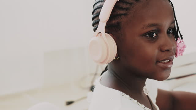 Beautiful African girl wearing headphones and listening to music