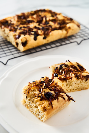Focaccia with caramelized onions, anchovies and black olives. Italian snacking bread. High quality photo