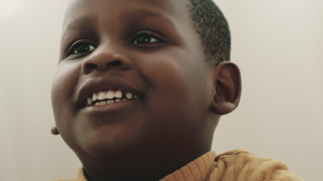 Close up portrait of black boy with smile  looking something