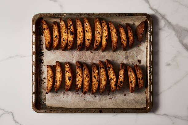 Freshly Baked Almond and Cranberry Biscotti on Parchment-Lined Baking Tray, Overhead Marble View. High quality photo