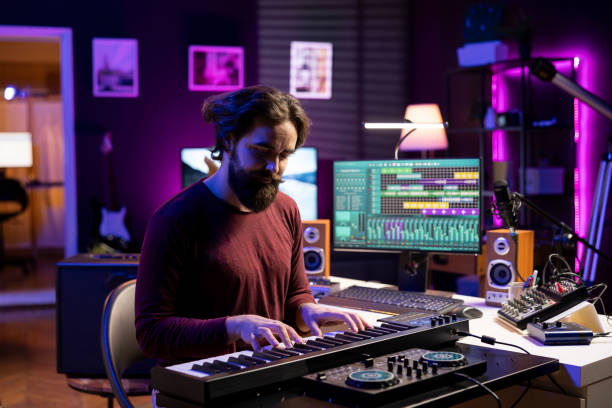 istock Young musician playing songs on piano midi controller in home studio 2129295227