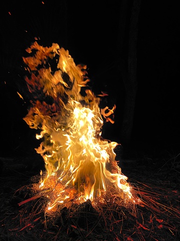 A close-up of a small fire with flames and dark smoke rising