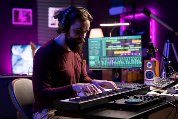 istock Musician playing electronic keyboard piano in his home studio 2129299910