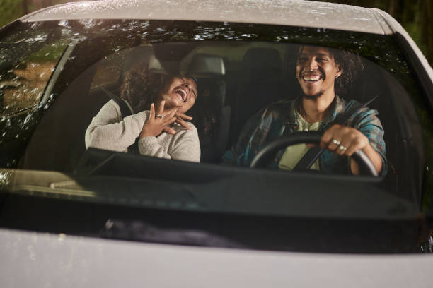 istock Cheerful black couple having fun while going on a trip by car. 2129311511