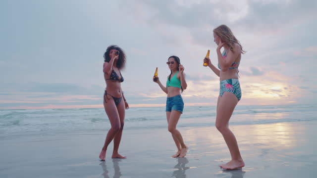 Group of friends having fun on the beach and drinking fruit juice. Summer beach.