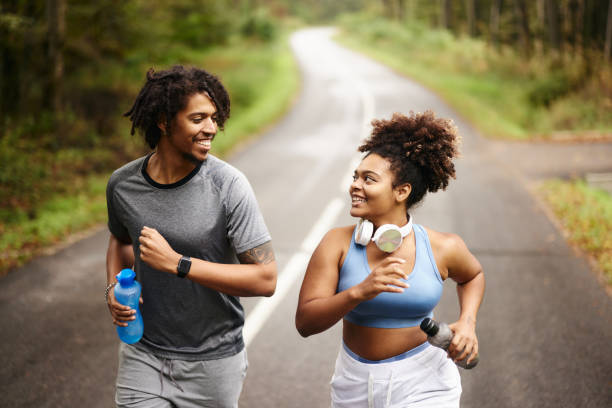 istock Happy black couple of athletes running on empty road. 2129321992
