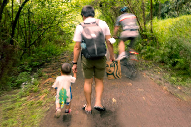 A family of diverse ages, outfitted in casual cycling gear, pedals together along a sun-dappled forest path, enjoying nature and exercise.