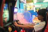 Teenage girl plays arcade racing games.
