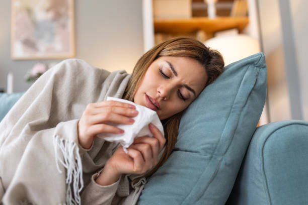 istock Sickness, seasonal virus problem concept. Woman being sick having flu lying on sofa. Sick woman lying in bed with high fever. Cold flu and migraine. 2129334105